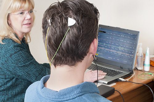 A biofeedback therapist performing therapy on a patient