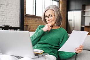 woman looking seriously at her computer screen examining results