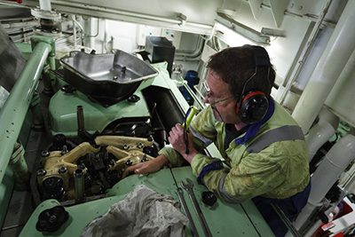 Man working on a ship's engine