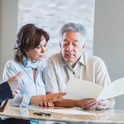 Pareja de mediana edad examinando un documento