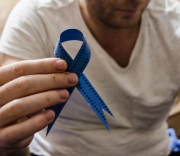 man holding a blue mesothelioma awareness ribbon